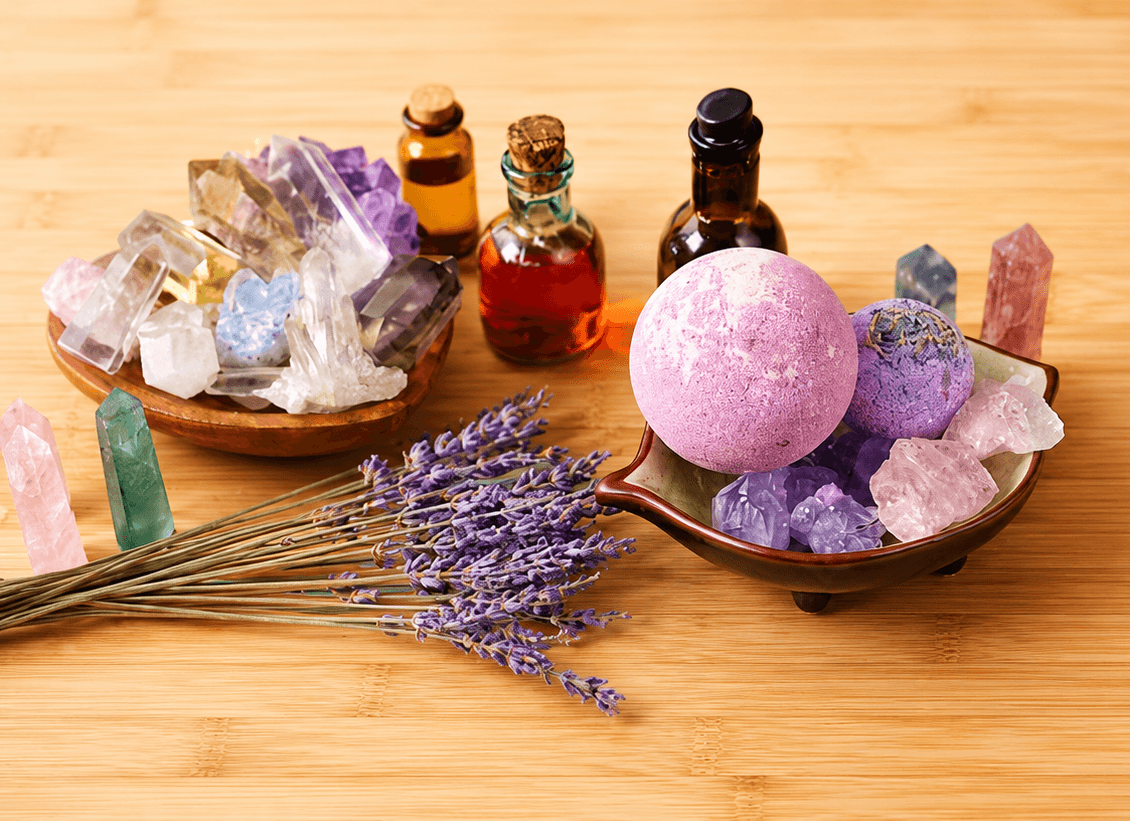 Crystal collection, lavender stems and amber bottles on wood.