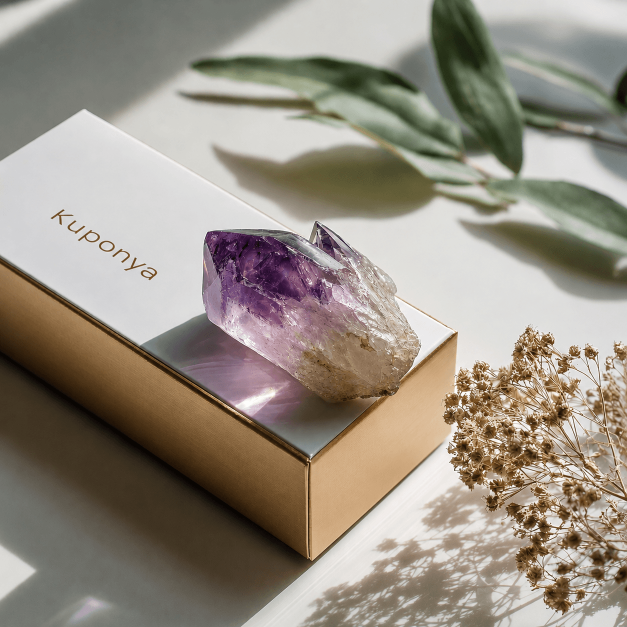 KUPONYA-branded paper box with an amethyst on top.